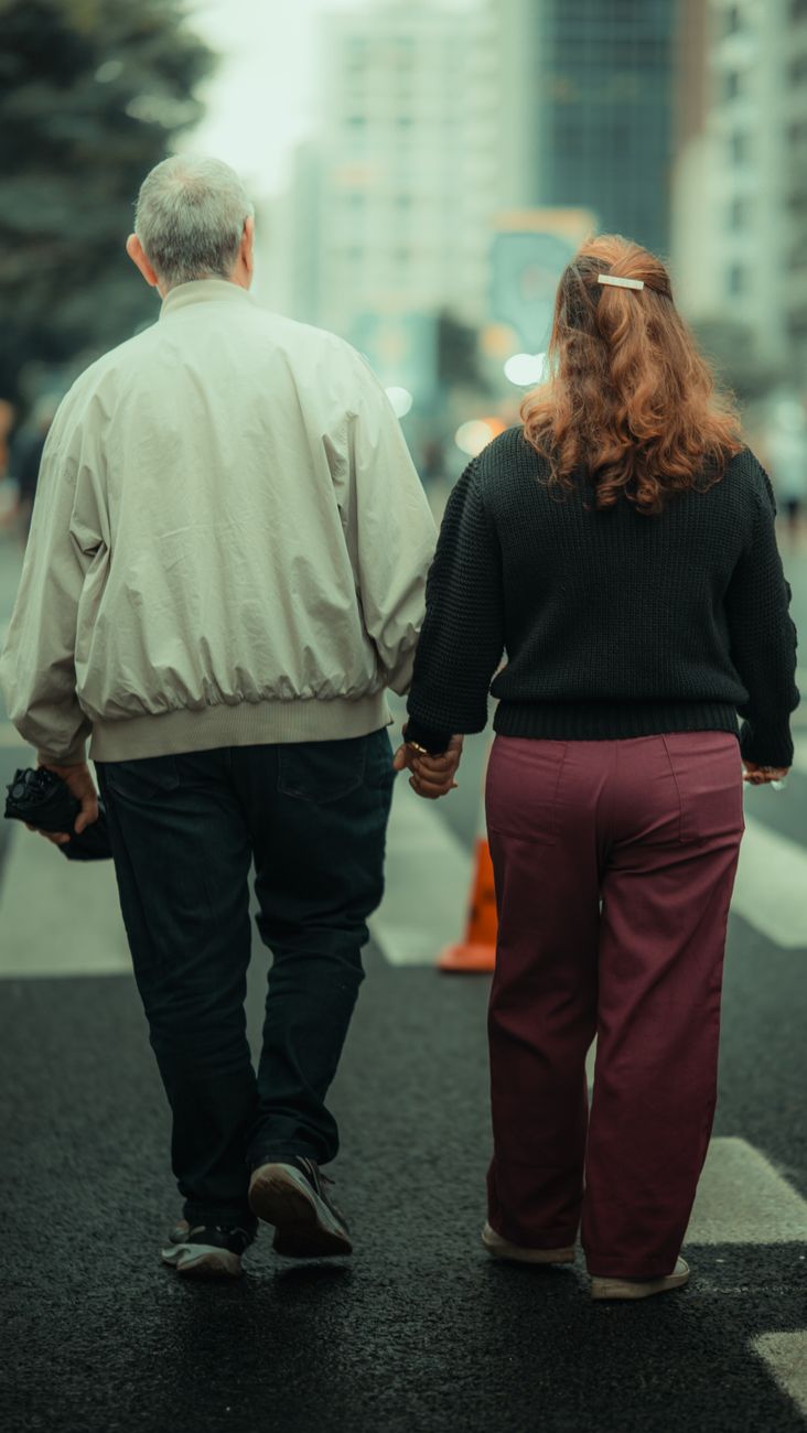 a couple walking down the street holding hands